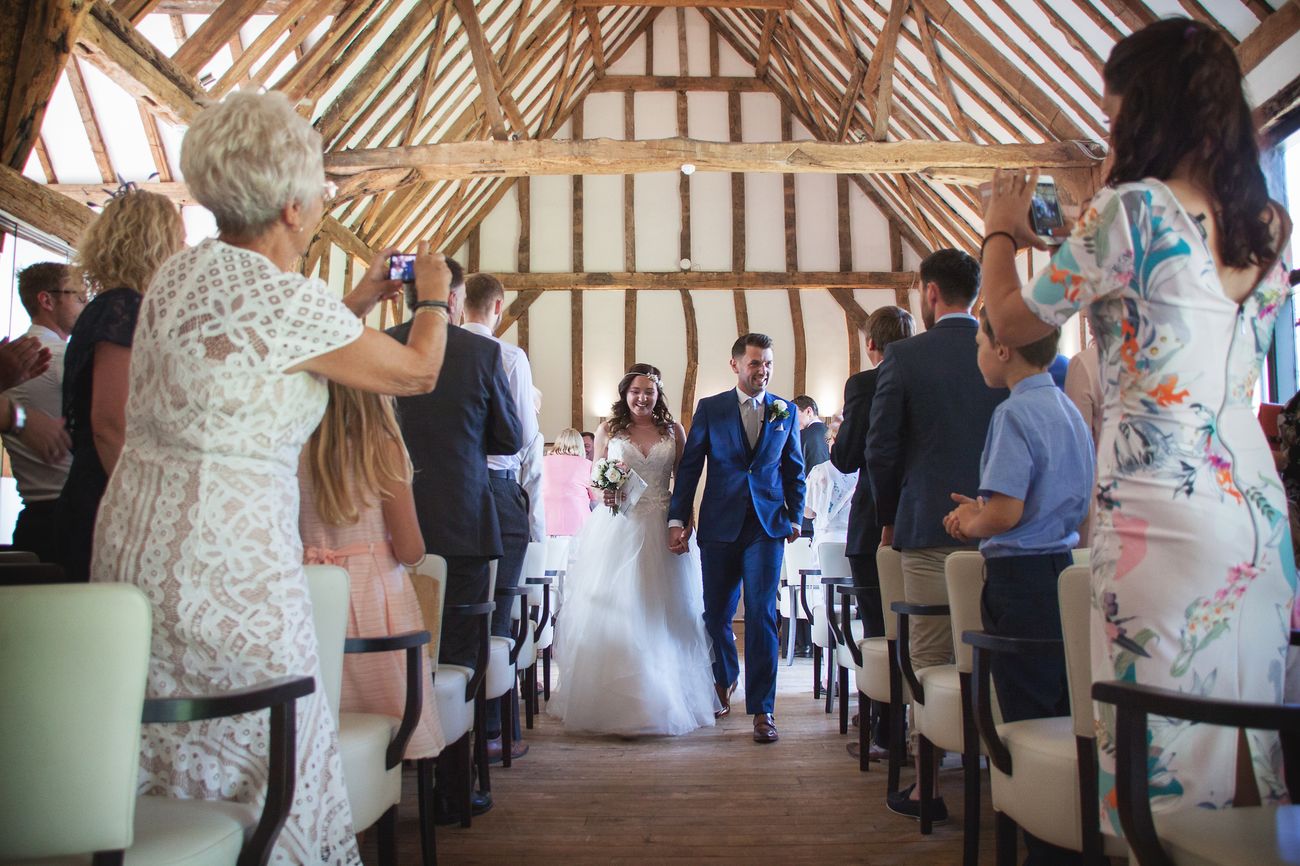 A bride walks down the aisle in the barn