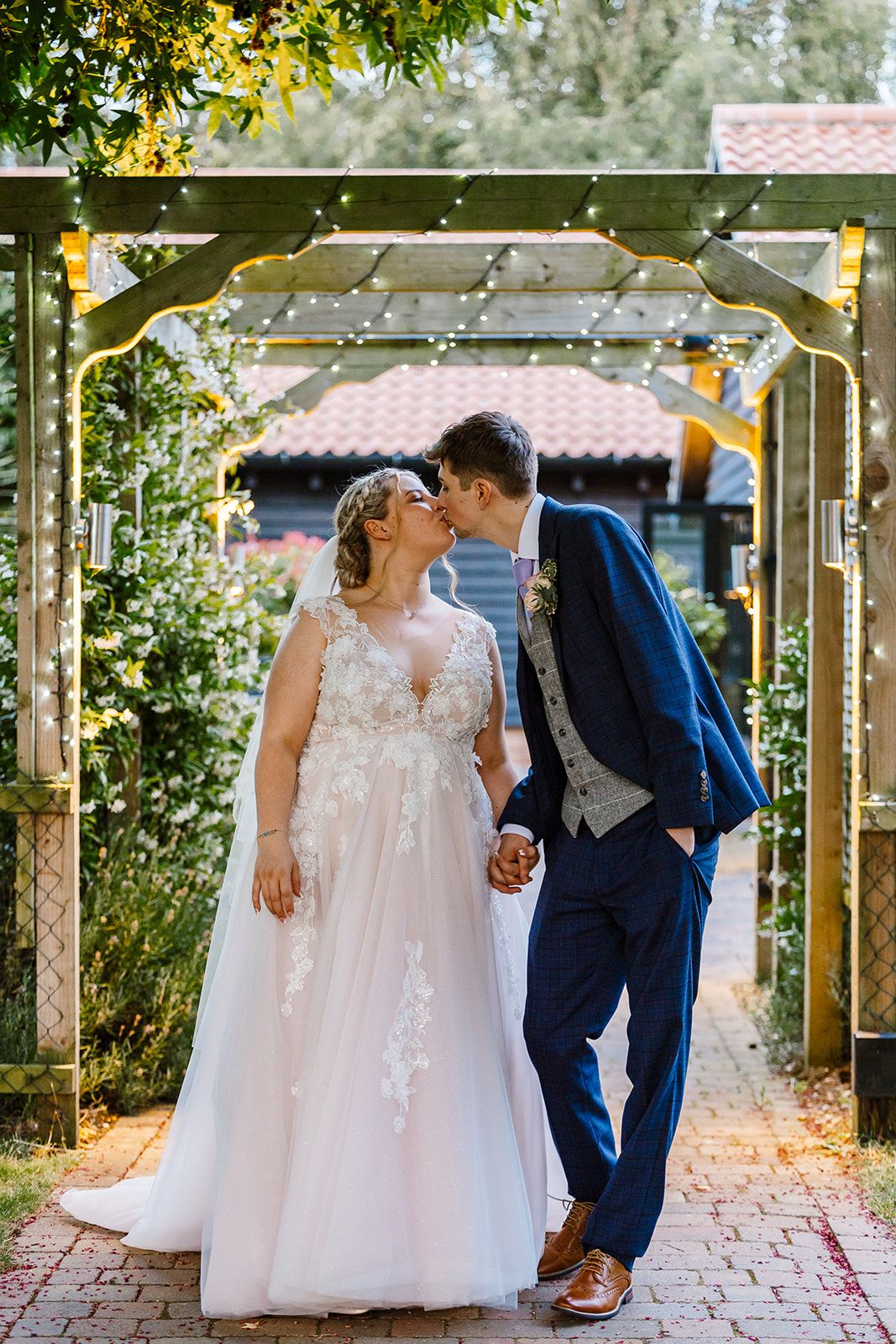 A couple beneath a floral arch in the gardens